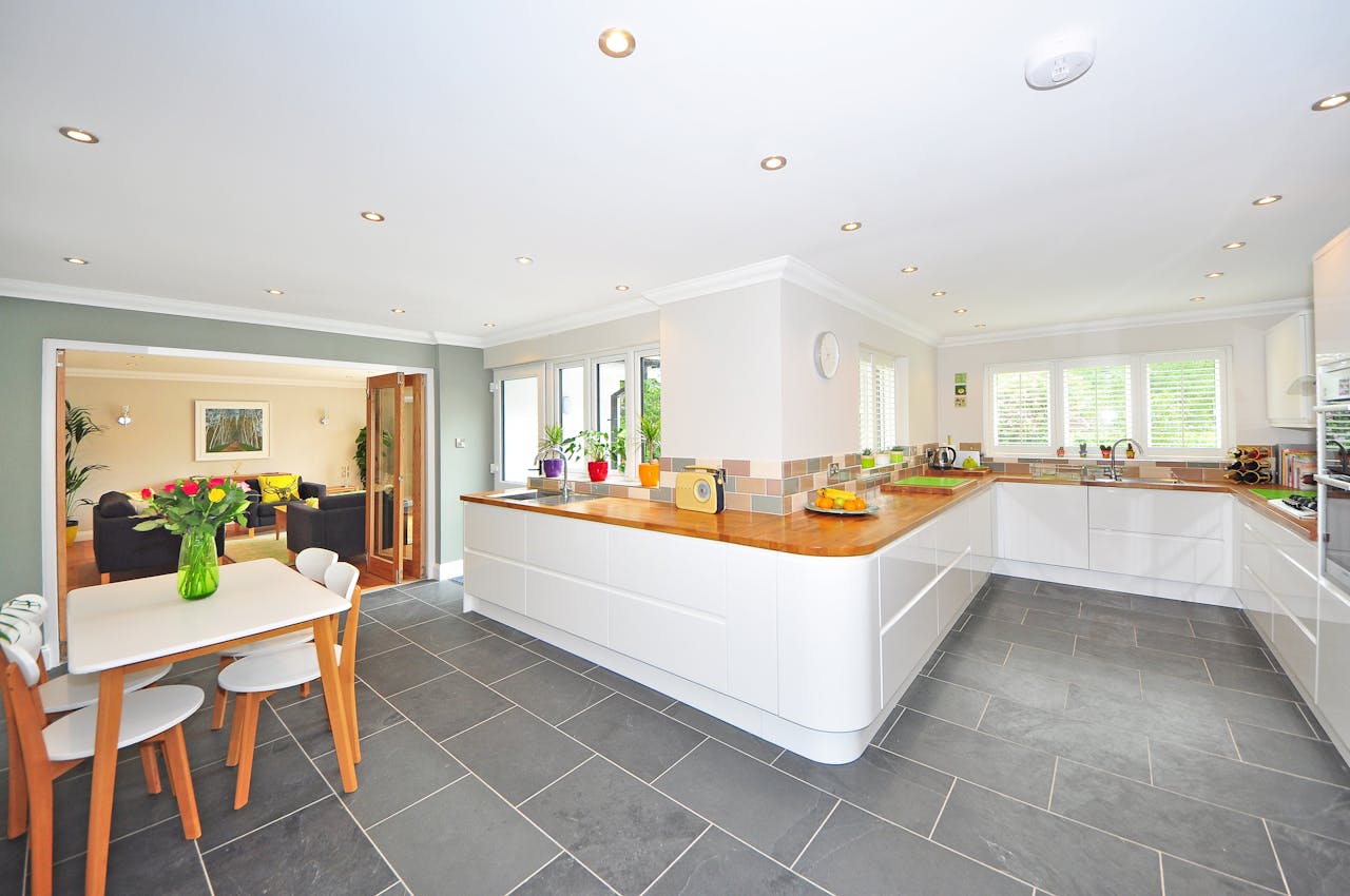 Offerings A spacious modern kitchen with elegant interiors featuring a dining table and luxurious design.