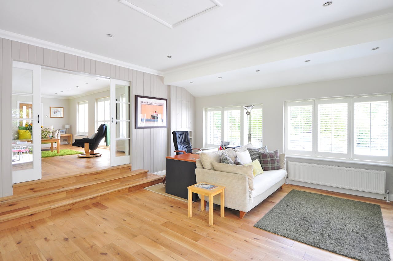 Offerings Spacious and bright modern living room with wooden floors and stylish furniture.