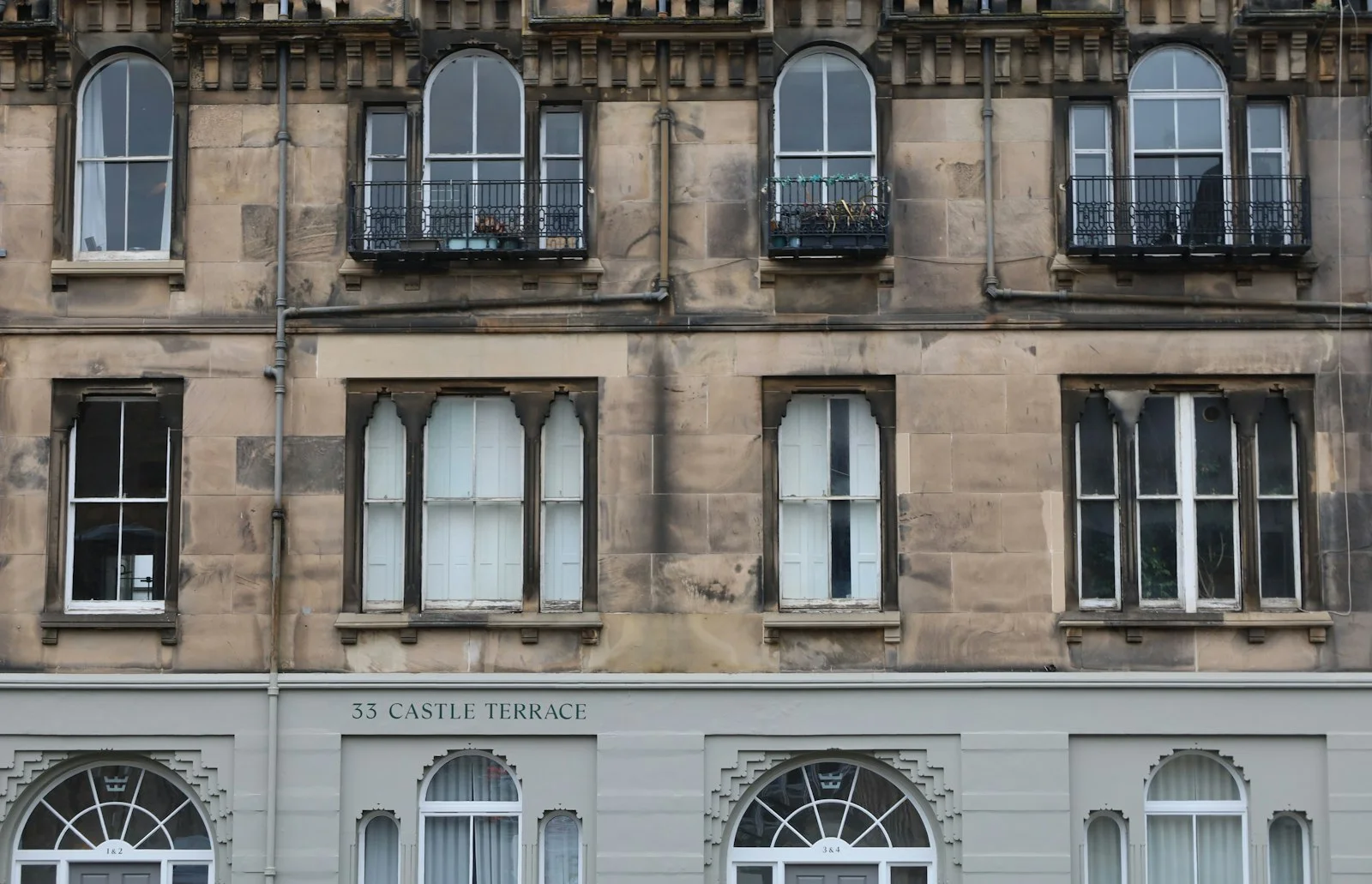 Stone building facade with multiple arched and rectangular windows Stone building facade with multiple arched and rectangular windows